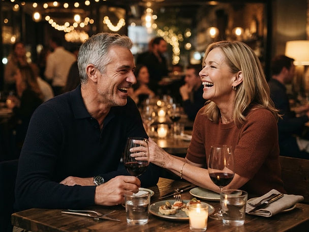 Paar lacht im Restaurant bei warmem Abendlicht